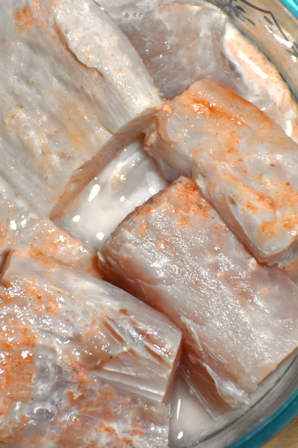 fish chunk in a bowl marinating with lime juice and hot sauce